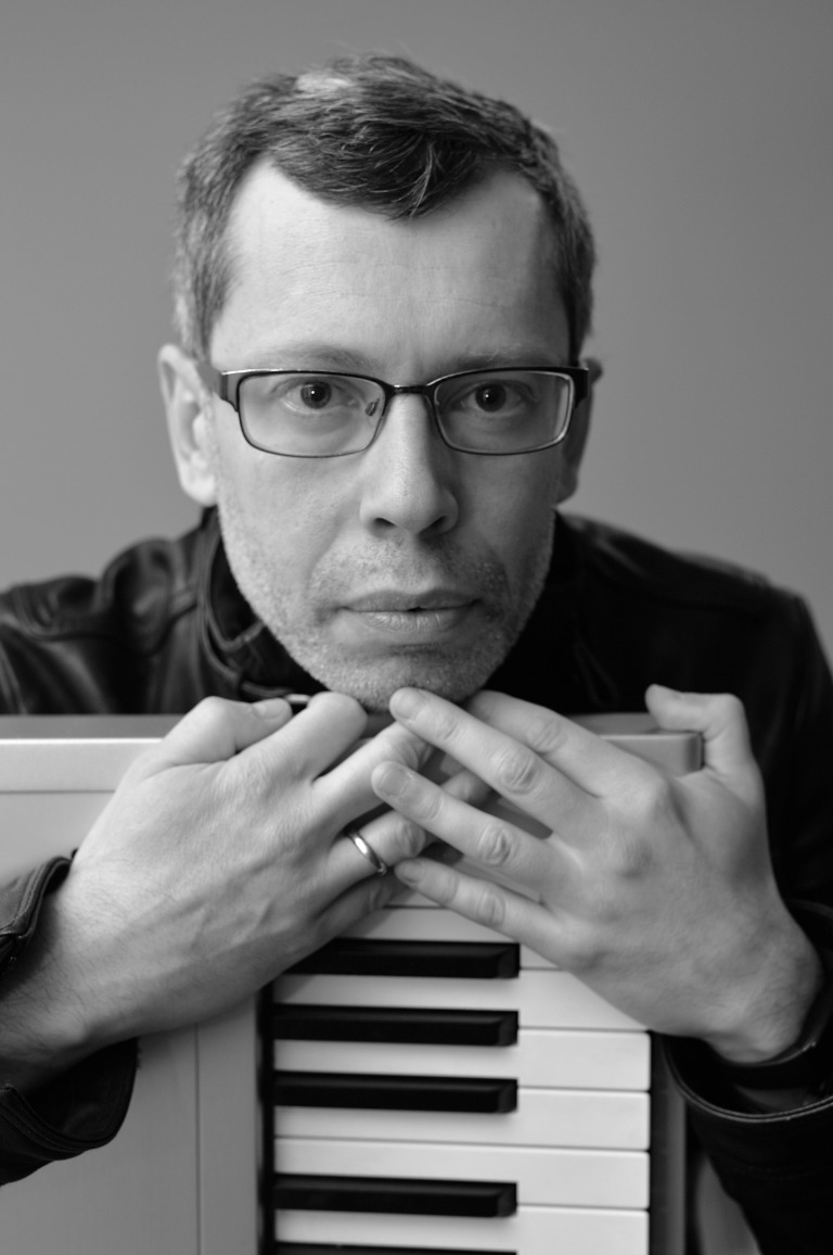 Black and white portrait of Mark Meitine with a keyboard